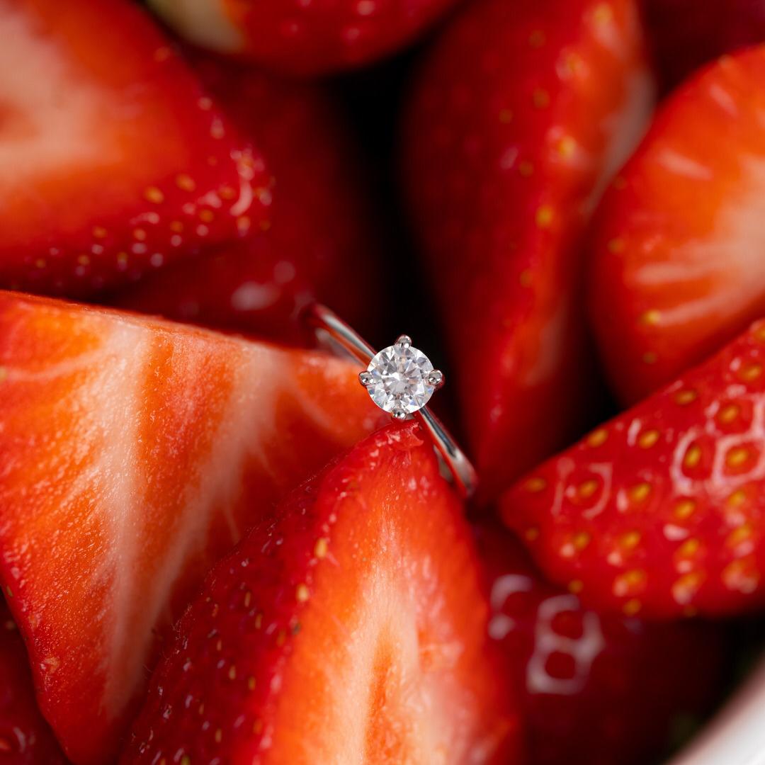 anillo de compromiso con diamante entre fresas frescas para celebrar el amor en san valentin